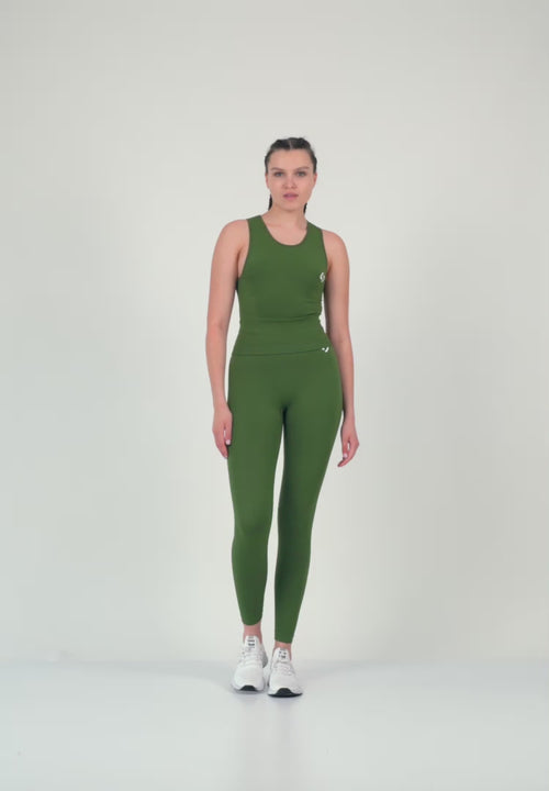 Color_Forest Green | A Women Wearing Black Beauty Color Zen Confidence Seamless Compressive Crop Top. Sculpted Silhouette