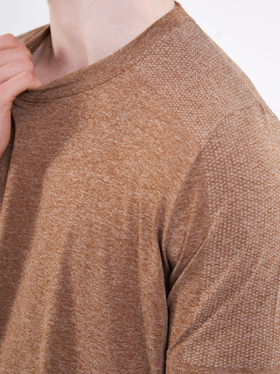 A Man Wearing Toffe Brown Color Unisex Seamless Melange T-Shirt. Enhanced Comfort