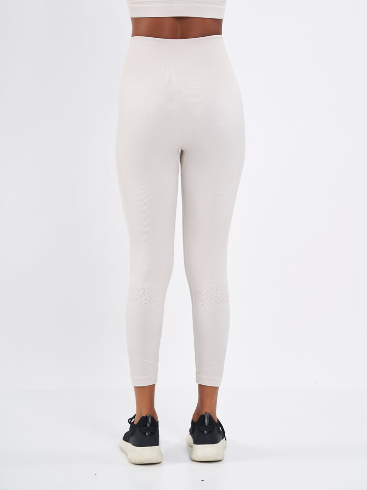 A Woman Wearing Sand Dune Color Seamless High-Waist Ankle-Length Ribbed Leggings. Super-Soft