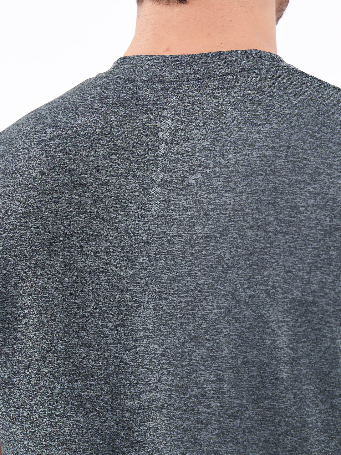A Man Wearing Deep Black Color Unisex Seamless Melange T-Shirt. Enhanced Comfort