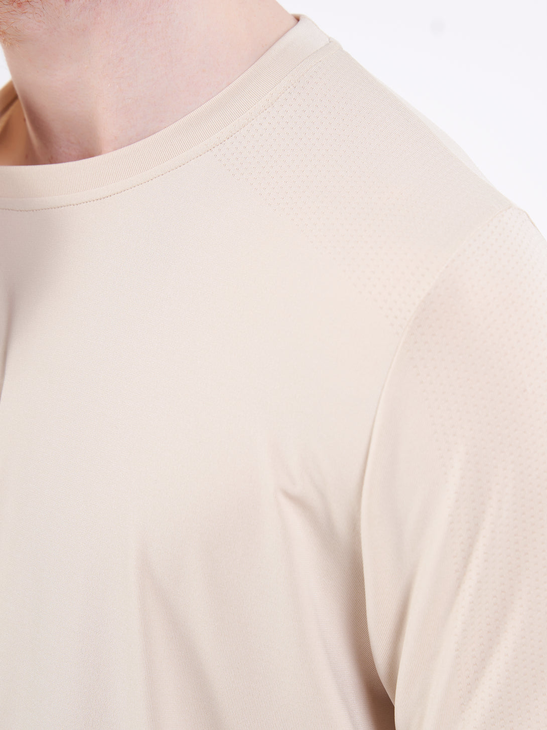 A Man Wearing White Sand Color Unisex Seamless Melange T-Shirt. Enhanced Comfort