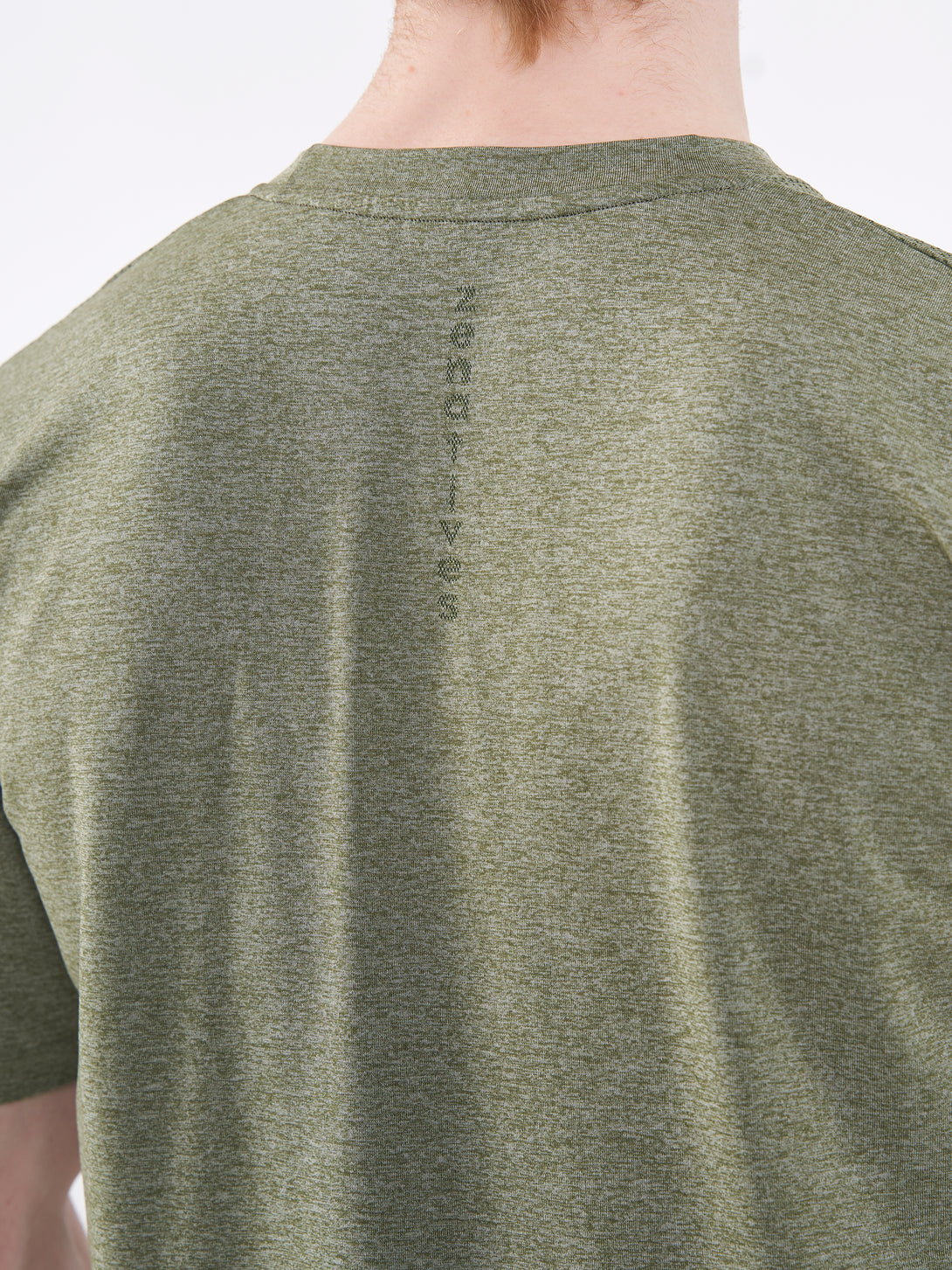 A Man Wearing Zen Khaki Color Unisex Seamless Melange T-Shirt. Enhanced Comfort