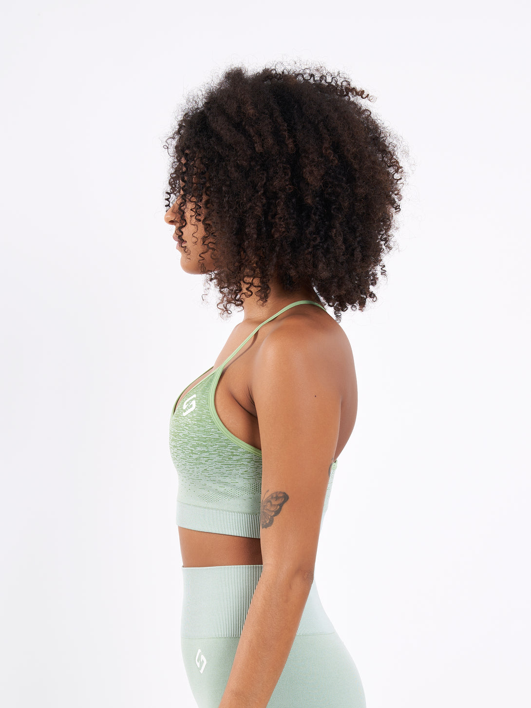 A Woman Wearing Mist Green Color Seamless Low-Impact Sports Bra with Ombre Effect. Chic Comfort