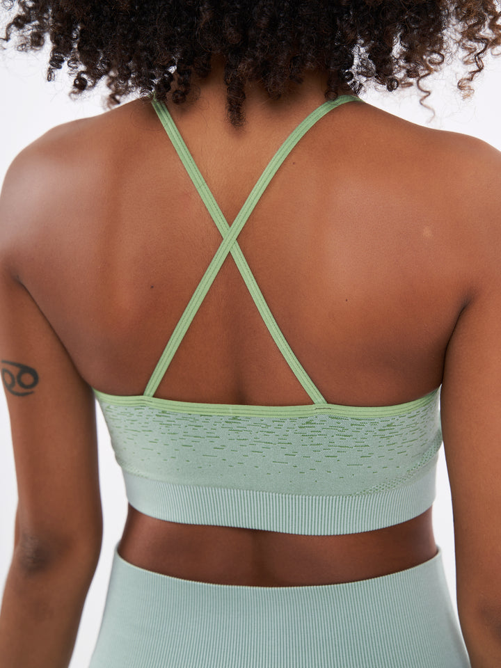 A Woman Wearing Misty Green Color Seamless Low-Impact Sports Bra with Ombre Effect. Chic Comfort