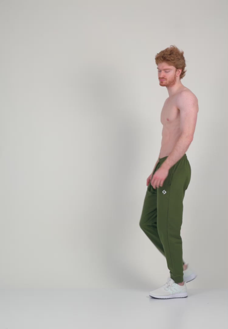 Farbe_Zen-Khaki | A Man Wearing Zen Khaki Color Men's Essential Comfort Joggers. Regular Fit