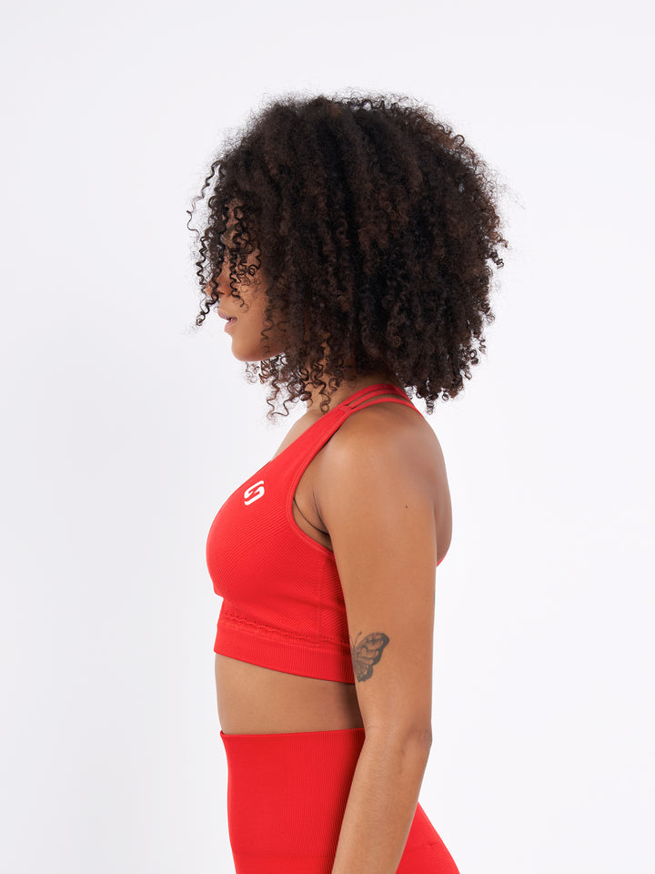 A Woman Wearing Bright Red Color Seamless Ribbed Mid-Impact Sports Bra Without Padding Flexible