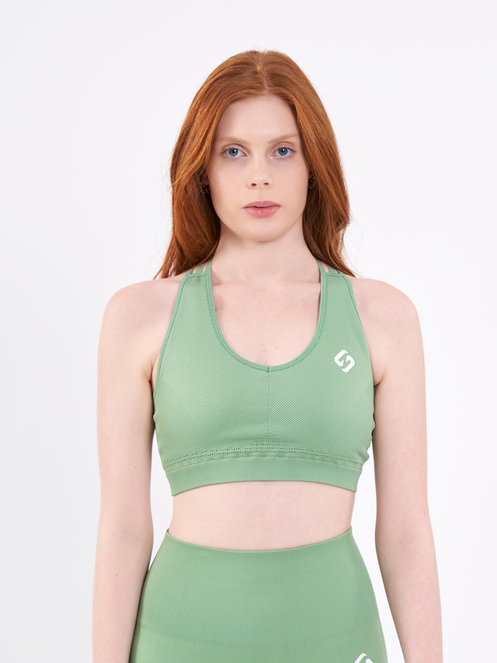 A Woman Wearing Misty Green Color Seamless Ribbed Mid-Impact Sports Bra Without Padding Flexible
