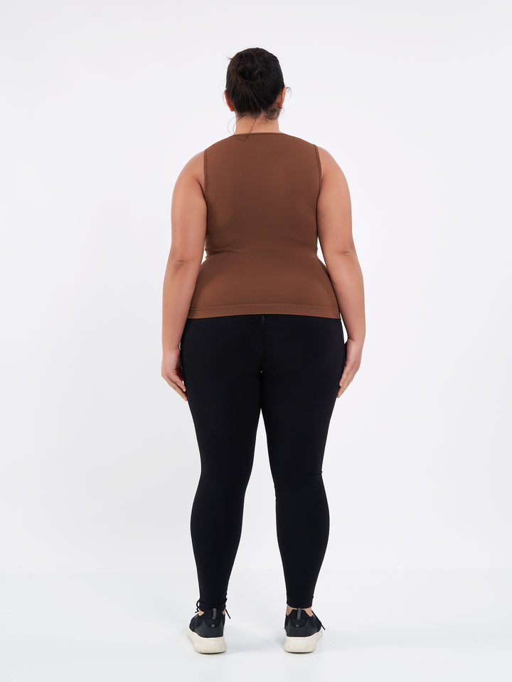 A Women Wearing Toffee Color Zen Confidence Seamless Compressive Crop Top. Sculpted Silhouette
