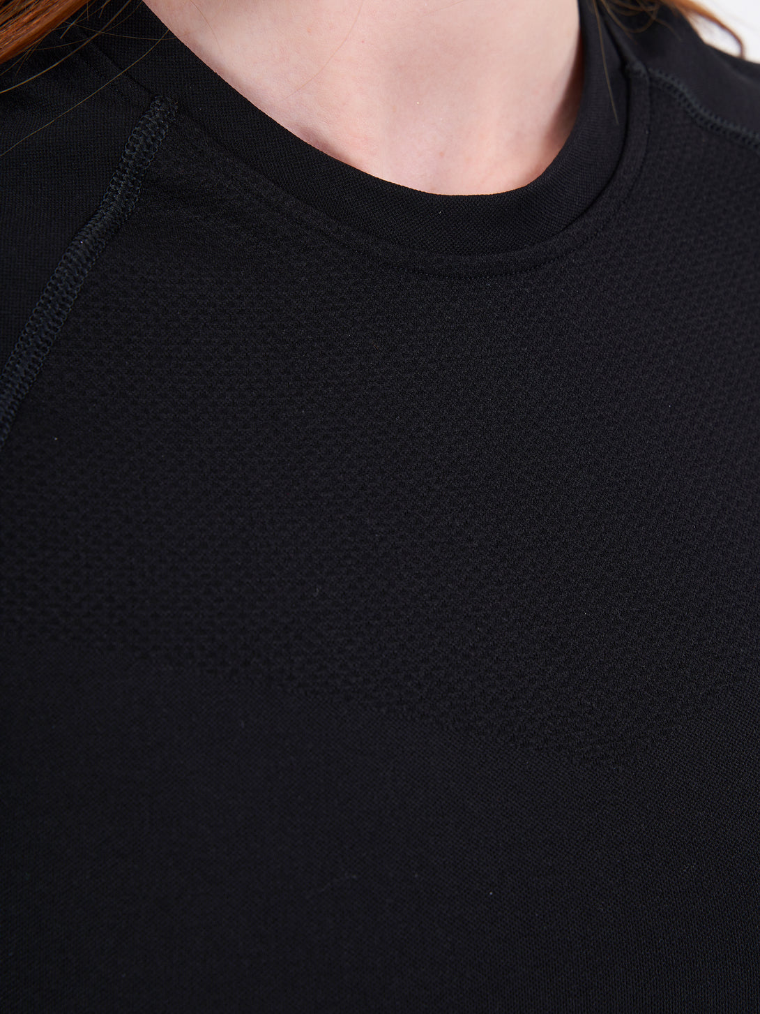 A Women Wearing Deep Black Color Zen Confidence Seamless Compressive T-Shirt. Sculpted Silhouette