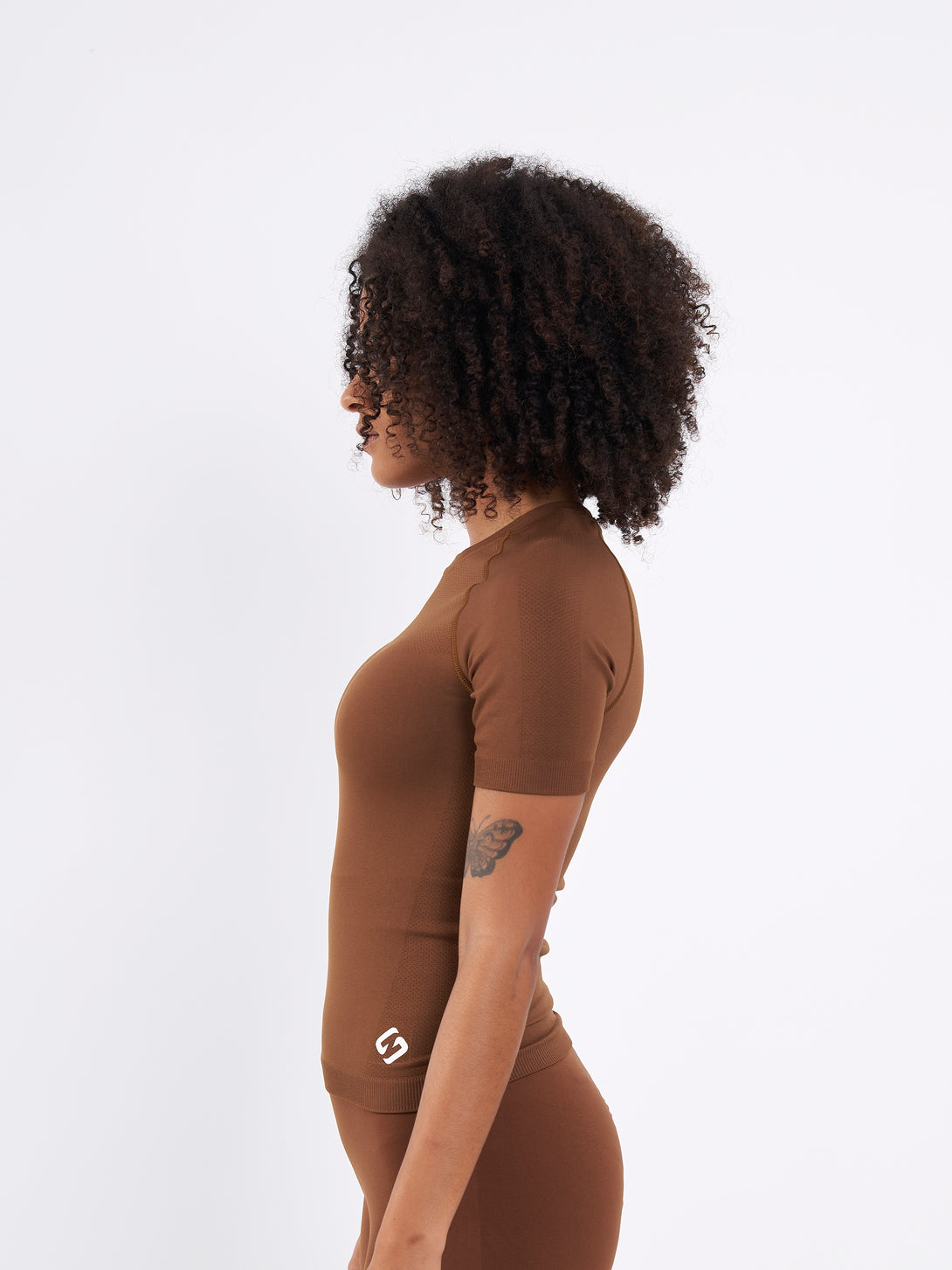 A Women Wearing Toffe Brown Color Zen Confidence Seamless Compressive T-Shirt. Sculpted Silhouette