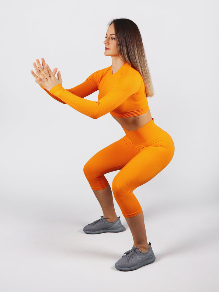 A Woman Wearing Orange Color The Main Long Sleeve Crop Top