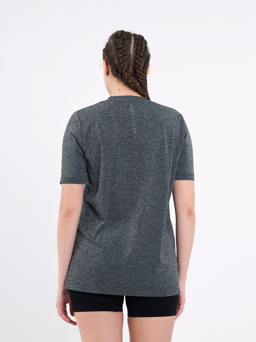 A Woman Wearing Deep Black Color Unisex Seamless Melange T-Shirt. Enhanced Comfort