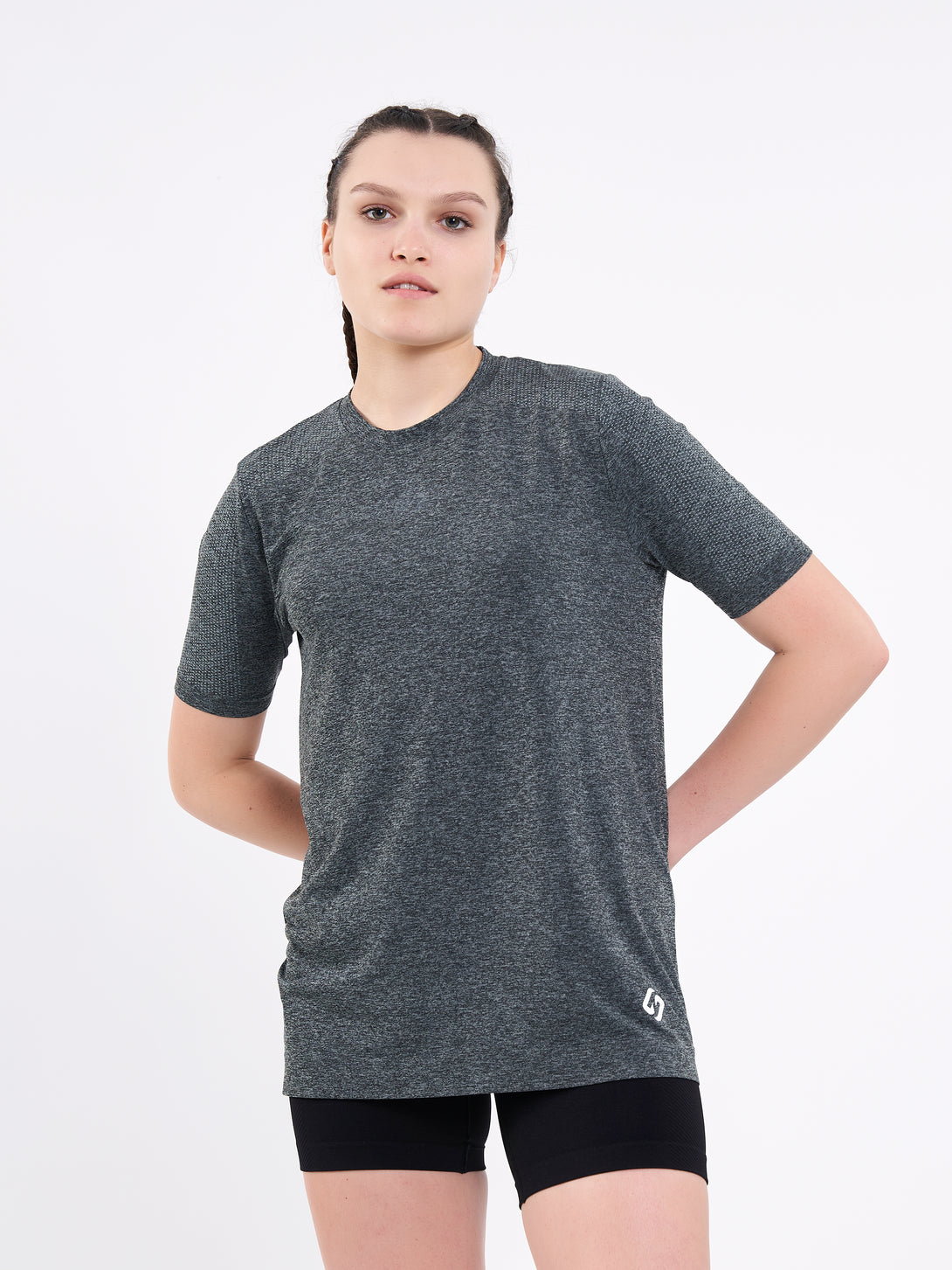 A Woman Wearing Deep Black Color Unisex Seamless Melange T-Shirt. Enhanced Comfort