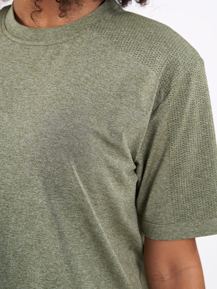 A Woman Wearing Zen Khaki Color Unisex Seamless Melange T-Shirt. Enhanced Comfort