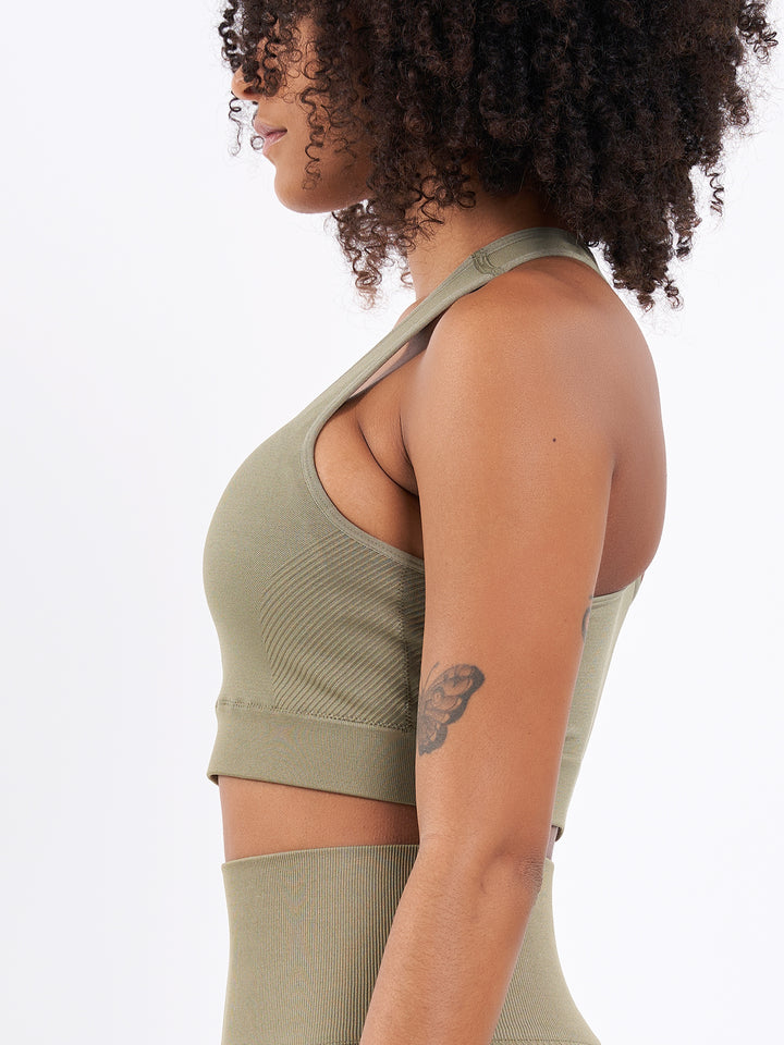 A Woman Wearing Olive Color Zen Perfect Seamless Mid-Impact Sports Bra With Padding
